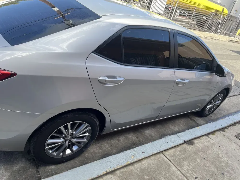 Side profile of a silver Toyota Corolla sedan parked at the curb